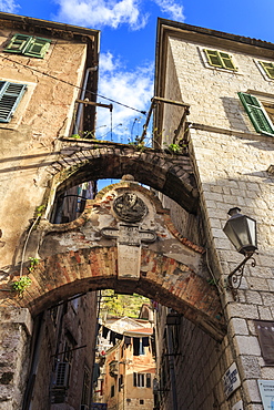 Old Town (Stari Grad), arch way with relief and hanging washing in an alley, Kotor, UNESCO World Heritage Site, Montenegro, Europe