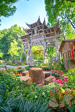 Traditional Chinese stone gate, a place to rest amidst lush vegetation and floral decorations at Wansong Academy, Hangzhou, Zhejiang, China, Asia