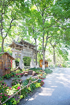 Traditional Chinese stone gate, lush surroundings and floral decorations at Wansong Academy, Hangzhou, Zhejiang, China, Asia