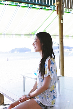 Japanese woman looking away near the beach