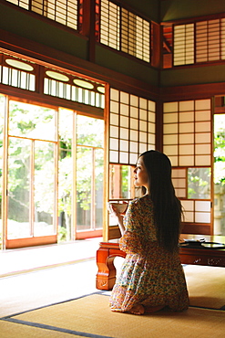 Japanese woman drinking green tea in a traditional Japanese house