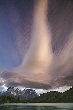 Cloud formations in the skies above the Torres del Paine National Park in Chile. Sunset over the waters of the sea, and snowcapped peaks, Torres del Paine national park, Chile