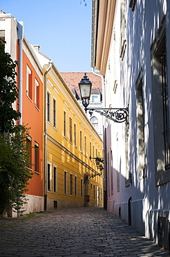 An empty cobbled alleyway with colourful houses in the Castle Quarter, Budapest, Hungary