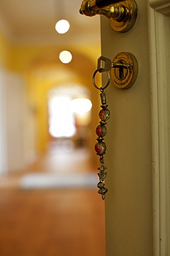 Close-up of door's keyhole with key hanging in lock