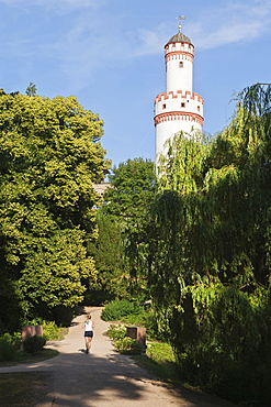 Rear view of women jogging in Castle Park in front of White Tower, Bad Homburg, Germany