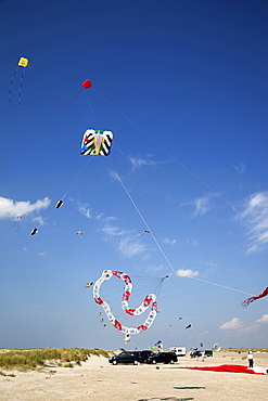 Multi-coloured flags in sky on kite festival at Fano beach, Denmark