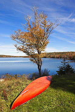 Upside down boat on grass in front of White Lake, Nova Scotia, Canada