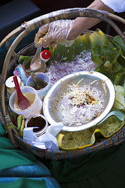 A snack seller offering stuffed banana leaf, onion and nut snacks on a train to Mandalay, Myanmar (Burma), Southeast Asia