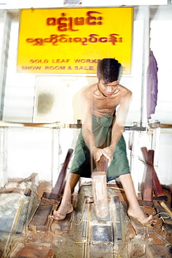 A gold beater beating pure gold into gold leaf, Mandalay, Myanmar, Southeast Asia