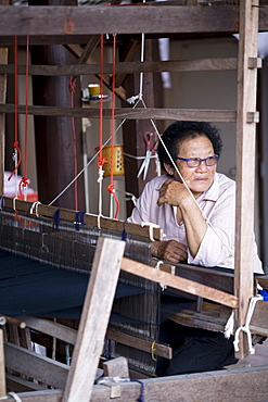 Tai Lue (Lu) indigenous weaver at a wooden loom weaving Tai Lue traditional clothing, Chiang Mai, Thailand, Southeast Asia, Asia