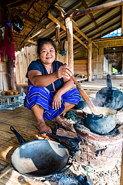 Indigenous White Karen (Kayin) hill tribe villager cooking at a traditional stove in a mountain village near Doi Inthanon, Chiang Mai, Thailand, Southeast Asia, Asia