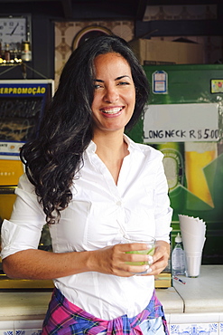 Young Brazilian woman 20 to 29 years old in a bar holding a caipirinha cocktail, Rio de Janeiro, Brazil, South America