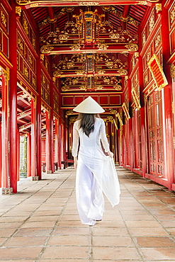 A woman in a traditional Ao Dai dress and Non La conical hat in the Forbidden Purple City of Hue, UNESCO World Heritage Site, Thua Thien Hue, Vietnam, Indochina, Southeast Asia, Asia