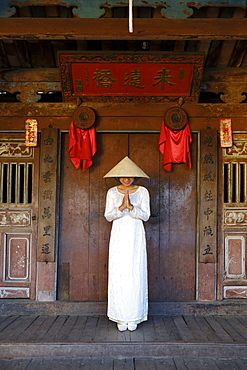 A young woman in a Non La conical hat and a traditional Ao Dai dress in the historical centre, Hoi An, Quang Nam, Vietnam, Indochina, Southeast Asia, Asia