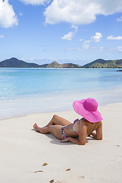 Lady on the sand surrounded by turquoise Caribbean Sea, Ffryes Beach, Sheer Rocks, Antigua and Barbuda, Leeward Islands, West Indies, Caribbean, Central America