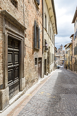 A medieval alley of the hill town with Piazza Duca Federico in the background, Urbino, Province of Pesaro, Marche, Italy, Europe