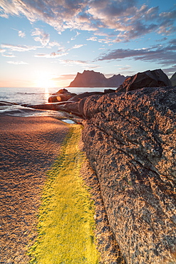 Lights of the midnight sun on the rocks surrounding the blue sea, Uttakleiv, Lofoten Islands, Northern Norway, Scandinavia, Europe