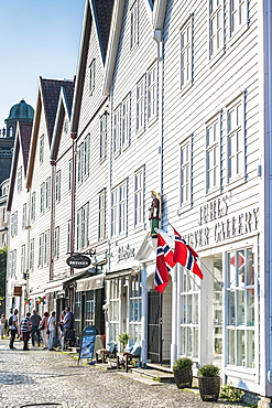 Norwegian flags hanging from white wood buildings and shops, Bryggen, Bergen, Hordaland County, Western Fjords region, Norway, Scandinavia, Europe