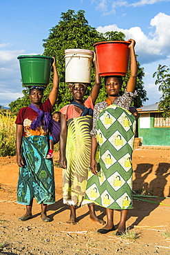 Local women carrying buckets on their heads, Malawi, Africa