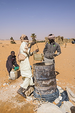 Local boys drawing water from their well in the desert between Ounianga Kebir and Faya, northern Chad, Africa