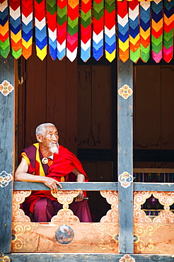 Monk watching the dancers at Paro festival, Paro, Bhutan, Asia