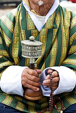 Local man holding a prayer wheel and beads, Paro District, Bhutan, Asia