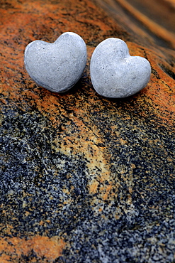 Two heart shaped stones on colourful stones in river bed, valley of verzasca, tessin, switzerland