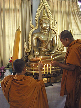 Thailand monks lighting candles at shrine wat prok bangkok