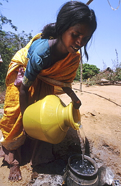 India - water: woman filling cooking pot with water, tamil nadu