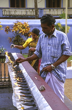 India: religion - christian lighting oil lamps. Valiapally catholic church, kerala