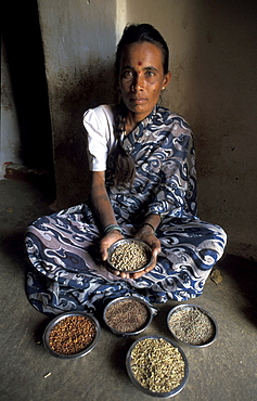 India padmanna, 30, displaying traditional lentil seeds, horse, red, cow and finger millet. Alaganahalli village, kolar, karnataka