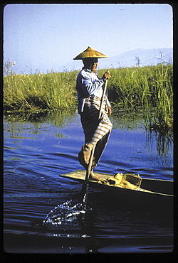 Color woman leg-rowing a canoe on. state, burma