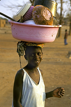 Mozambique woman carrying dishes to nyasa where she, metangula