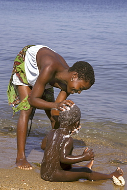 Mozambique mother washing her on the shore of nyasa, metangula