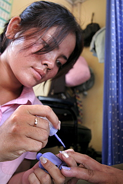 Cambodia stylist varnishing nails at a beauty shop in phnom penh.