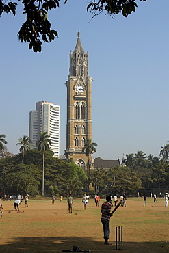 India cross maidan with cricket game, old and new buildings in background, mumbai.