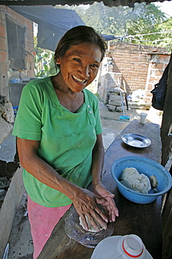 Honduras woman making tortillas. slum barrio of chamelecon, pedro sula