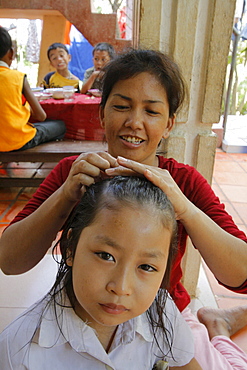 Woman combing girls hair