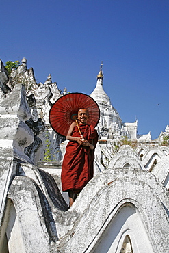 Myanmar monk with sunshade at white stupa, mingun, near mandalay 