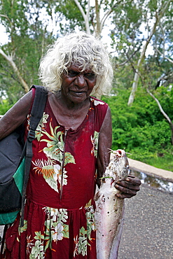 Australia. Older aborigine woman who jhas just caught a catfish, aborigine community of , or beswick, arnemland, northern territory. 2007