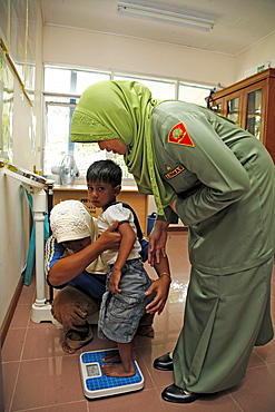 Indonesia government health clinic (pos kesmas) at cot seumereng, desa pucoh leung. weighing a child. meulaboh, aceh