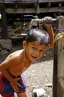 Indonesia boy taking a bath at a crs provided tap in paloh village, pulo aceh, aceh. 2 years after the tsunami