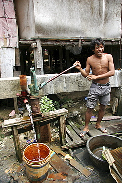 Thailand slum dweller pumping water, chiang mai