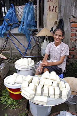 Vietnam woman selling tofu in a street market of hanoi