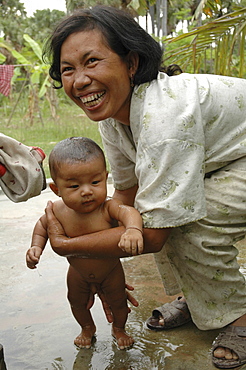 Cambodia woman washing child, kampong thom