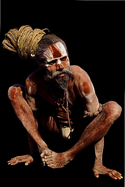 Aside from a life of simplicity focus on divine, many sadhus engage in a diverse array of practices both internal external in order to attain higher states of awareness consciousness. This sadhu chosen hatha yoga shows results--a well-disciplined, strong body--while holding kukkuta asana, or cock posture. India