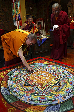 Sang sang rimpoche uses the dorje, a sacred ritual object to make the first decisive cut into the sand mandala on the last day of the mani rimdu festival. chiwang monastery, solu khumbu, nepal. solu khumbu, nepal