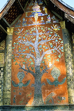 Glass mosaic of tree of life on wall of the 16th century Sim, Wat Xiang Thong, Luang Prabang, UNESCO World Heritage Site, Laos, Indochina, Southeast Asia