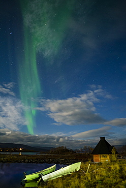 Aurora borealis over lake with boats and Kota, Kilpisjarvi, Northwest Finland, Lapland, Finland, Scandinavia, Europe