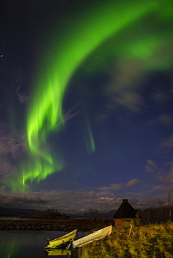 Aurora borealis over lake with boats and Kota, Kilpisjarvi, Northwest Finland, Lapland, Finland, Scandinavia, Europe